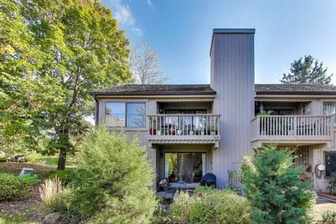 a view of house with roof deck and furniture