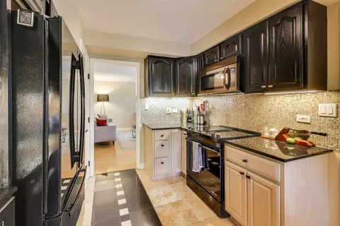 a kitchen with stainless steel appliances granite countertop a stove a refrigerator and a sink