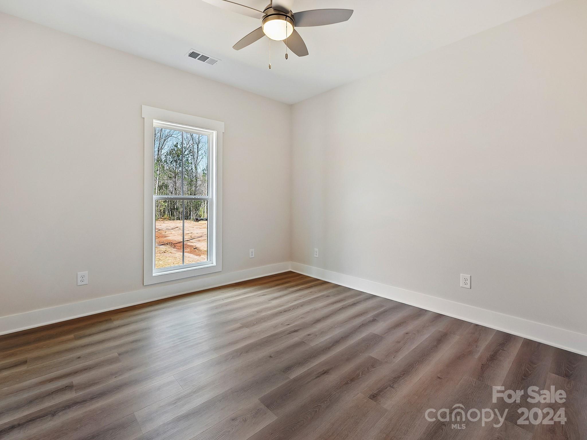 194 Old Pinckney Road York, SC 29745 - Photo 26 of 30 an empty room with wooden floor chandelier fan and windows