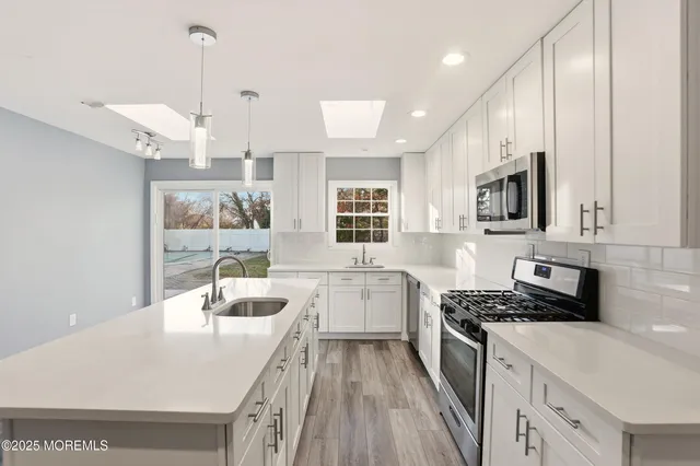 a kitchen with a sink stove and wooden floor