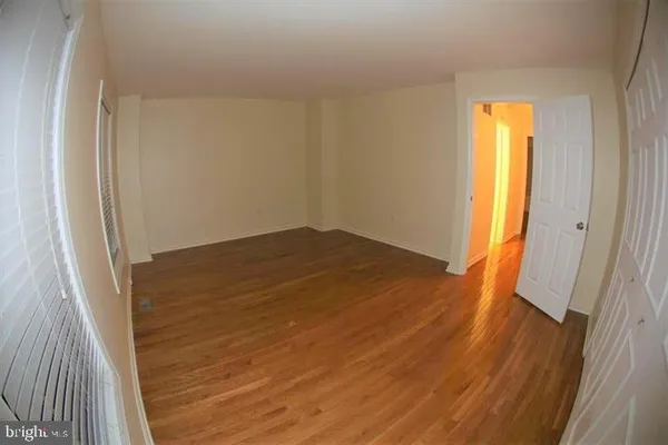 an empty room with wooden floor and a window