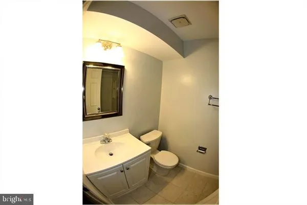 a bathroom with a toilet a sink and mirror