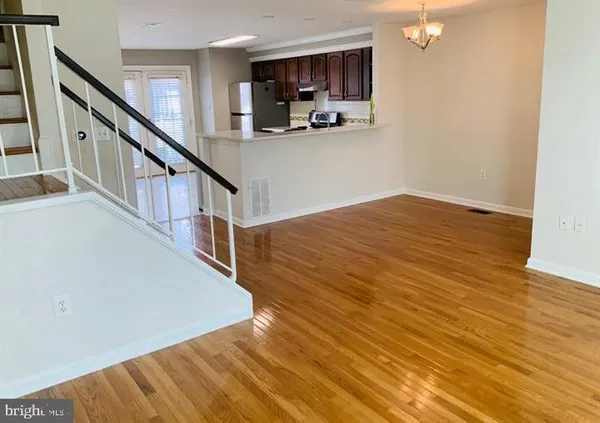 a view of a kitchen with furniture and wooden floor