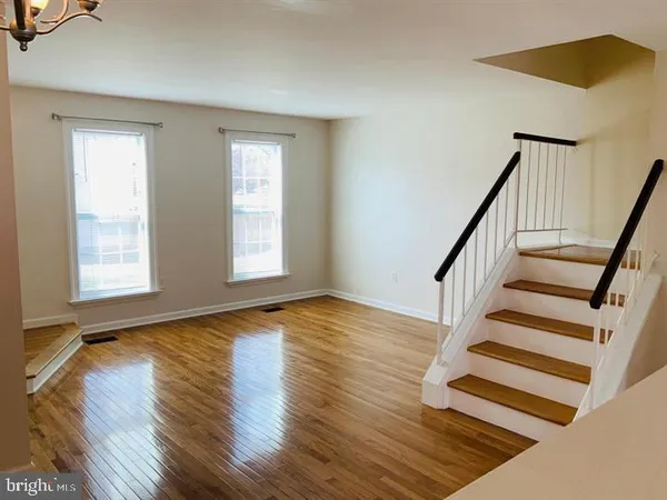 wooden floor in an empty room with a window and wooden floor