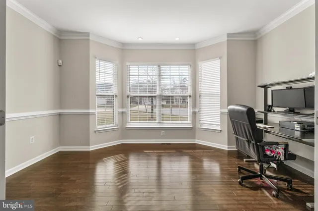 a view of a workspace with furniture and wooden floor