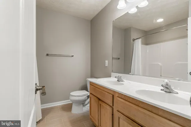 a bedroom with a bed a flat screen tv and a chandelier