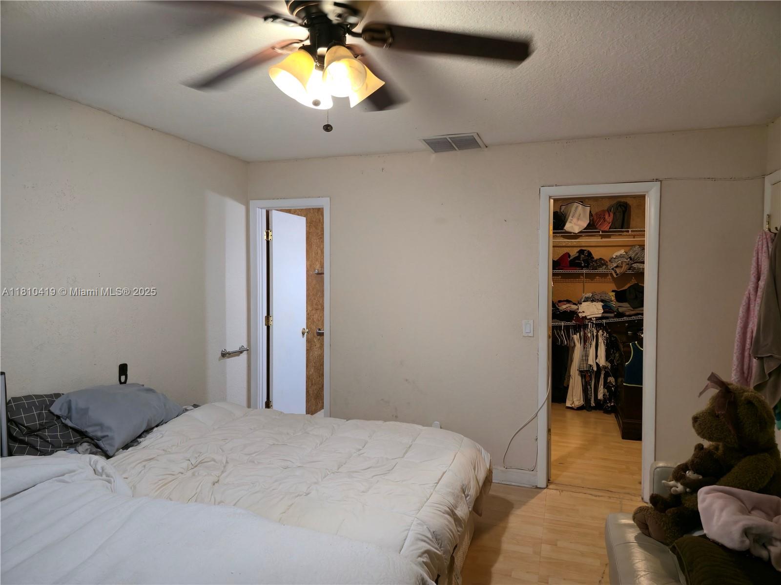 22374 Southwest 57th Circle Boca Raton, FL 33428 - Photo 12 of 31 a bedroom with a bed and a chandelier