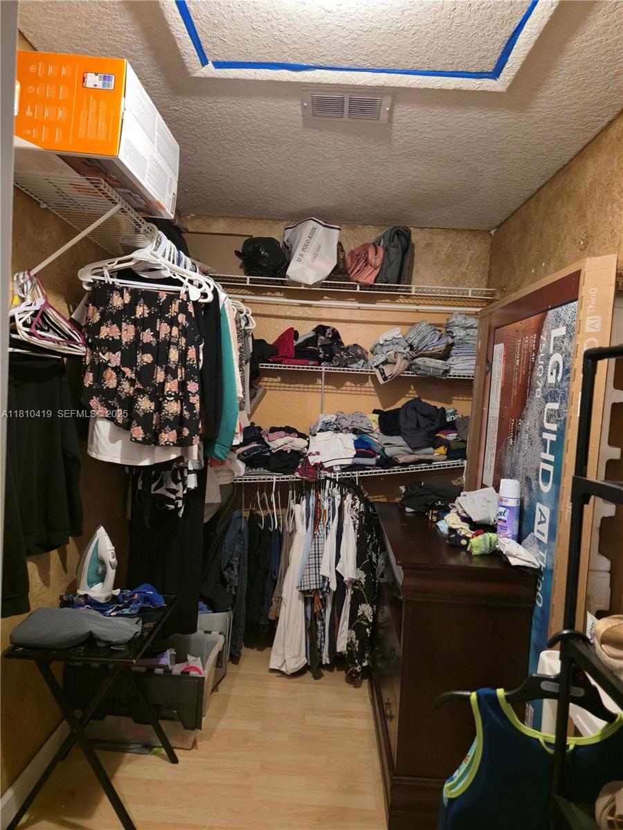 22374 Southwest 57th Circle Boca Raton, FL 33428 - Photo 13 of 31 a view of walk in closet with clothes and shoes