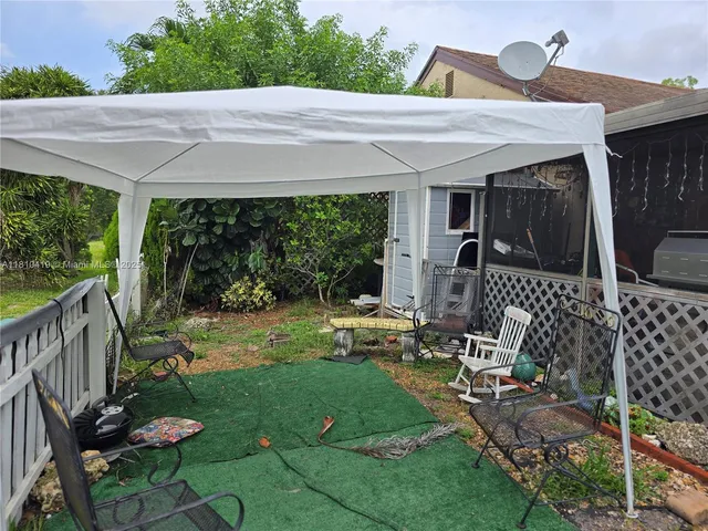 a view of backyard with a table and chairs and potted plants
