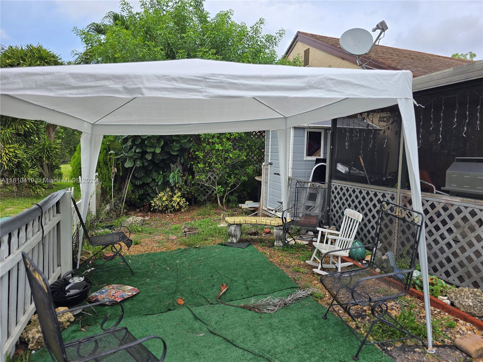 22374 Southwest 57th Circle Boca Raton, FL 33428 - Photo 26 of 31 a view of backyard with a table and chairs and potted plants