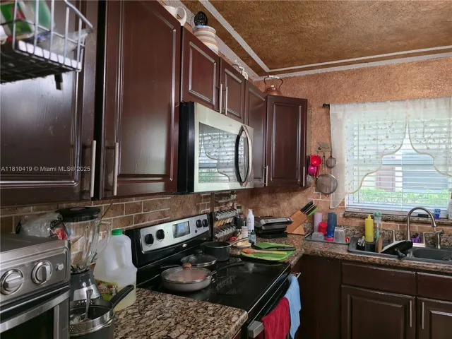 a kitchen with a stove a sink and a cabinets