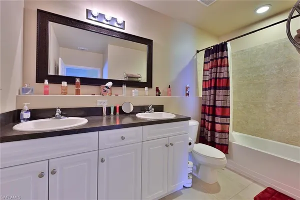 a en suite bathroom with a granite countertop sink and a mirror