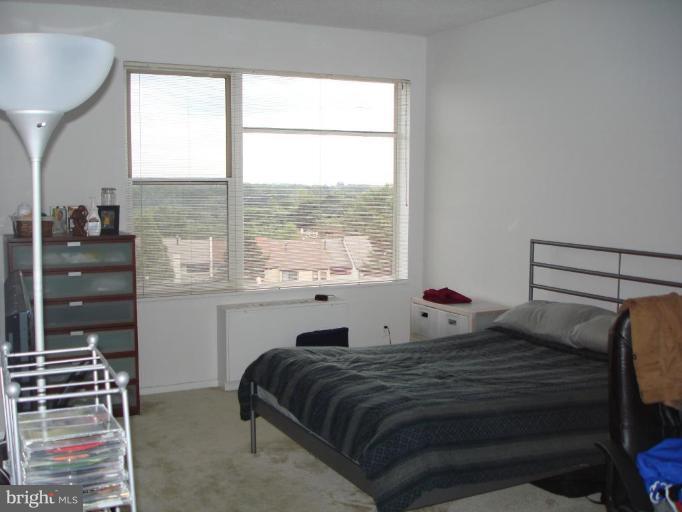 4401 Roland Avenue, Unit 607 Baltimore, MD 21210 - Photo 11 of 16 a bedroom with a bed and a window