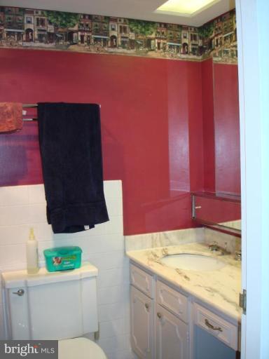 4401 Roland Avenue, Unit 607 Baltimore, MD 21210 - Photo 12 of 16 a bathroom with a sink toilet and mirror