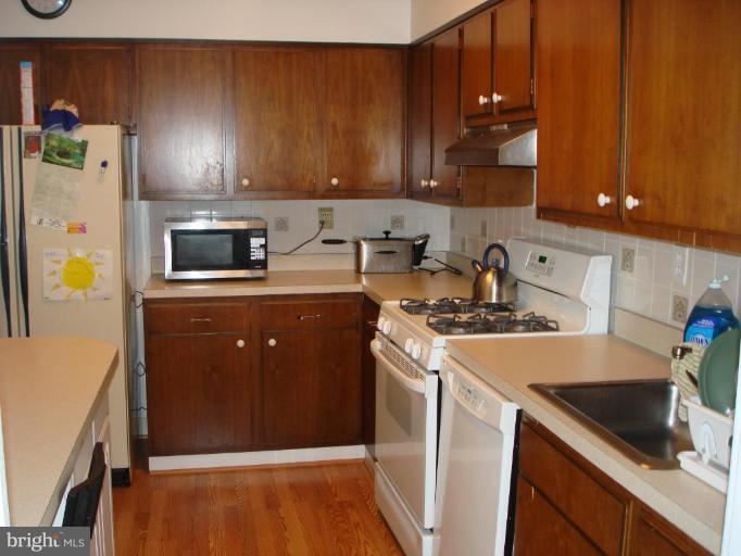 4401 Roland Avenue, Unit 607 Baltimore, MD 21210 - Photo 8 of 16 a kitchen with a sink a stove and cabinets