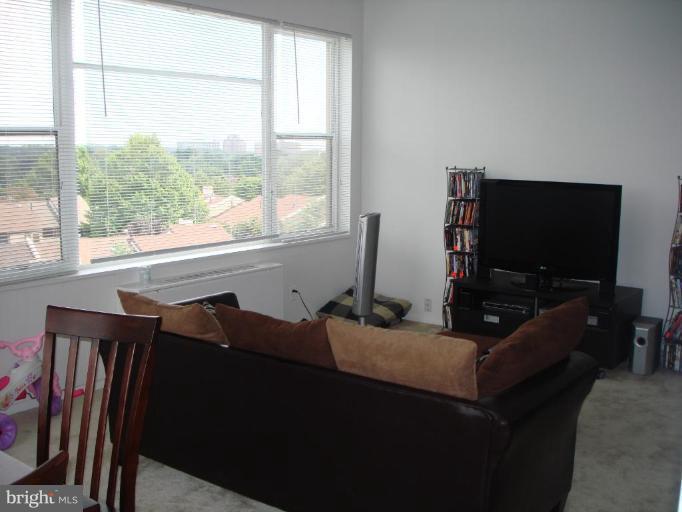 4401 Roland Avenue, Unit 607 Baltimore, MD 21210 - Photo 9 of 16 a living room with furniture and a flat screen tv