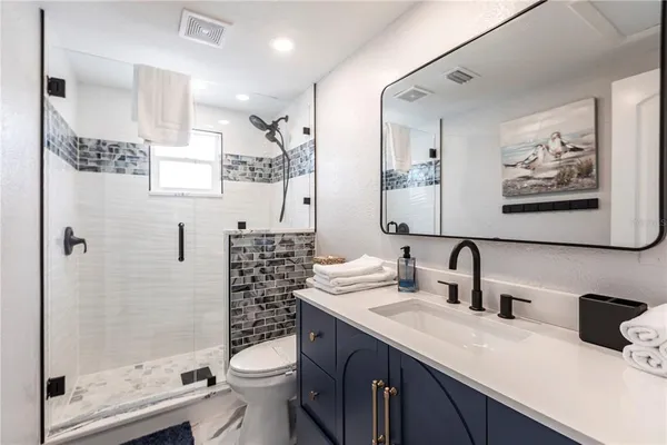 a bathroom with a double vanity sink toilet and shower