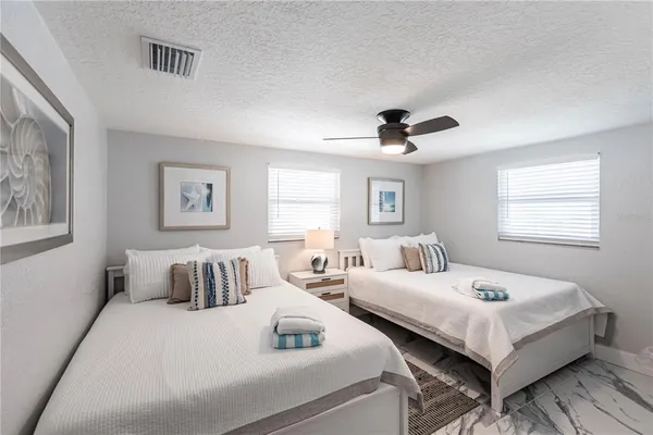 a bedroom with two beds and a window