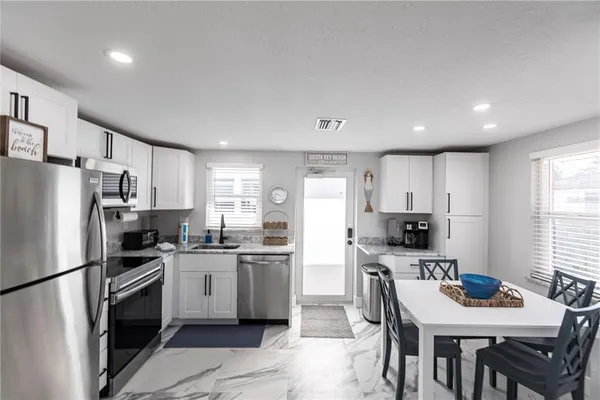 a kitchen with stainless steel appliances a refrigerator stove microwave and cabinets