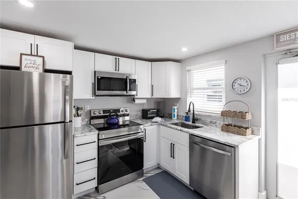 a kitchen with stainless steel appliances granite countertop a refrigerator stove a sink dishwasher and a refrigerator with wooden cabinets
