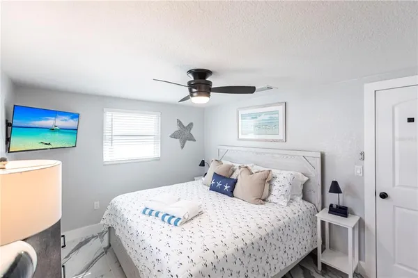 a bedroom with a bed and a flat tv screen on the dresser