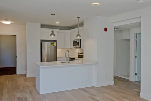a view of a kitchen with a sink and a refrigerator