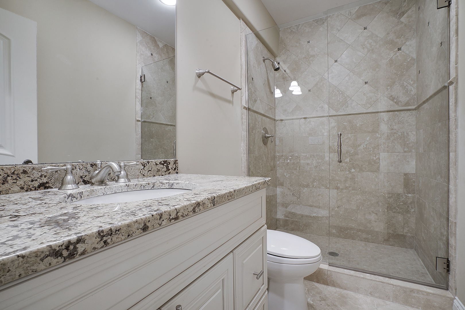 1004 Lee Road Northbrook, IL 60062 - Photo 29 of 30 a bathroom with a granite countertop sink a toilet and shower