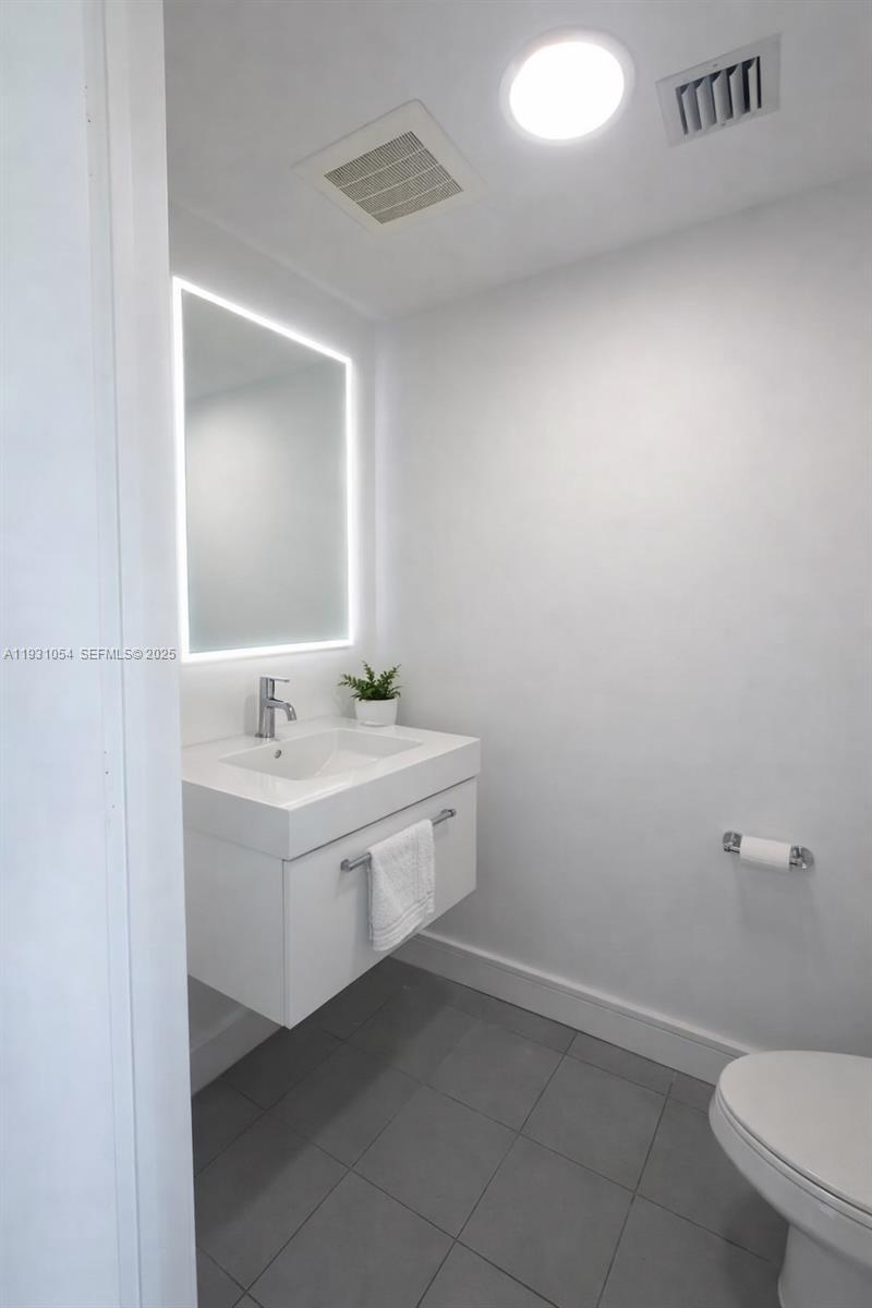 92 Southwest 3rd Street, Unit 1408 Miami, FL 33130 - Photo 7 of 15 a bathroom with a sink a toilet and mirror