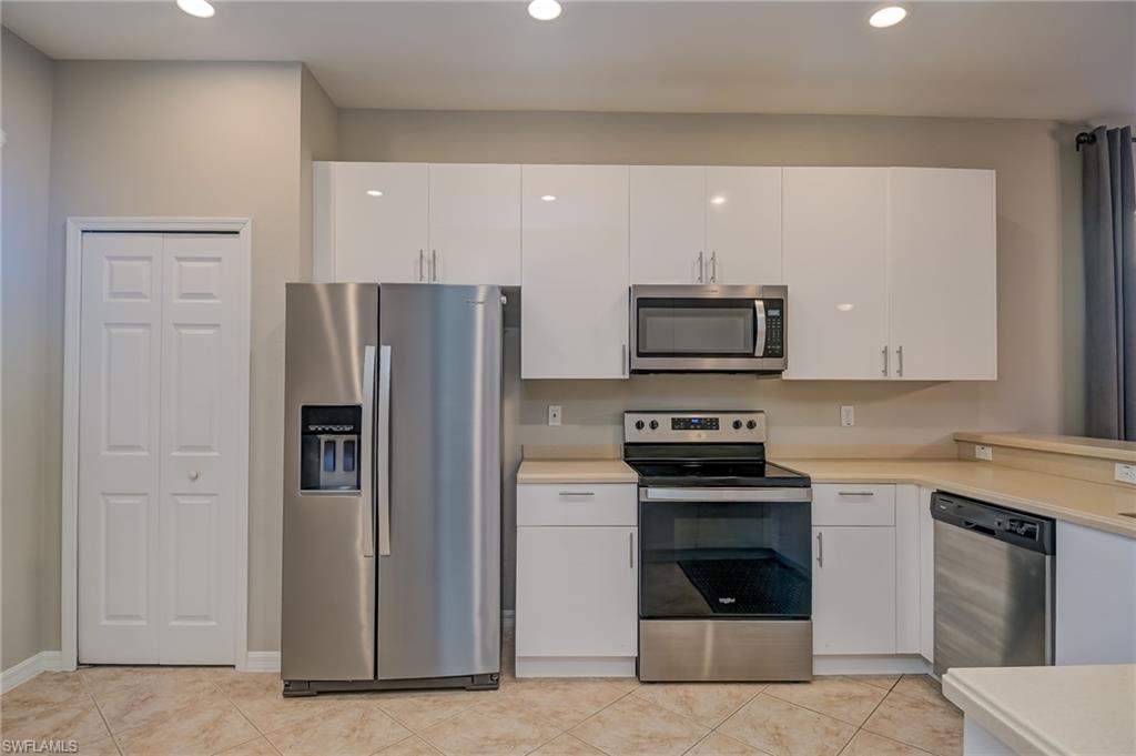 7658 Bristol Circle Naples, FL 34120 - Photo 2 of 32 a kitchen with a stove and a refrigerator