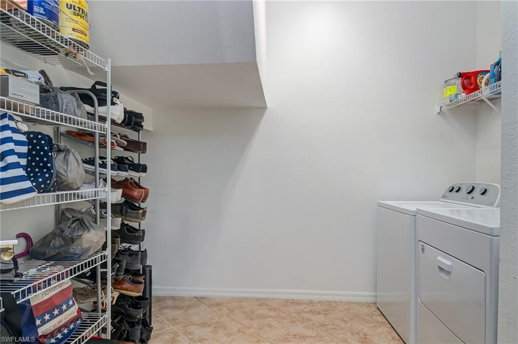 7658 Bristol Circle Naples, FL 34120 - Photo 21 of 32 a view of walk in closet with clothes and shoes