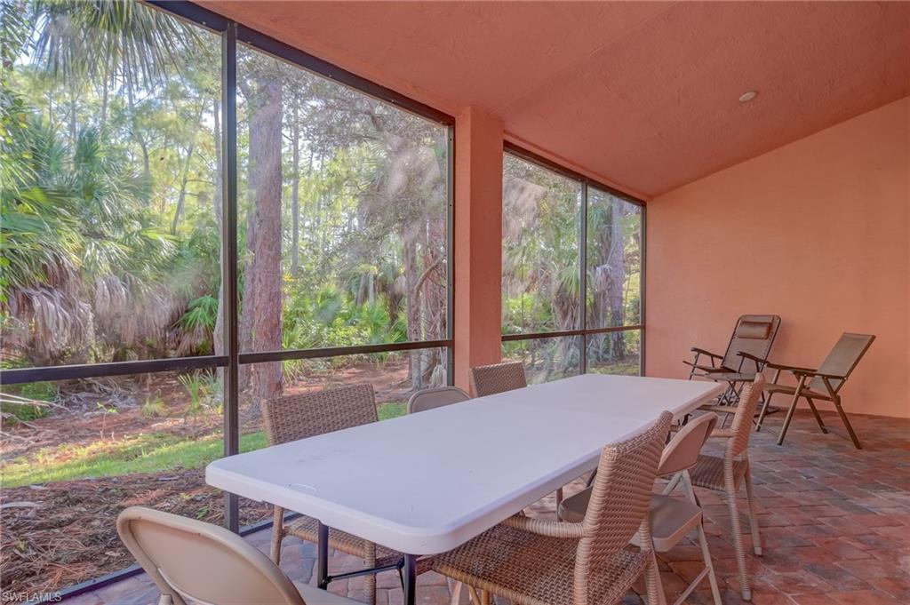 7658 Bristol Circle Naples, FL 34120 - Photo 23 of 32 a view of a patio with table and chairs with wooden floor and fence