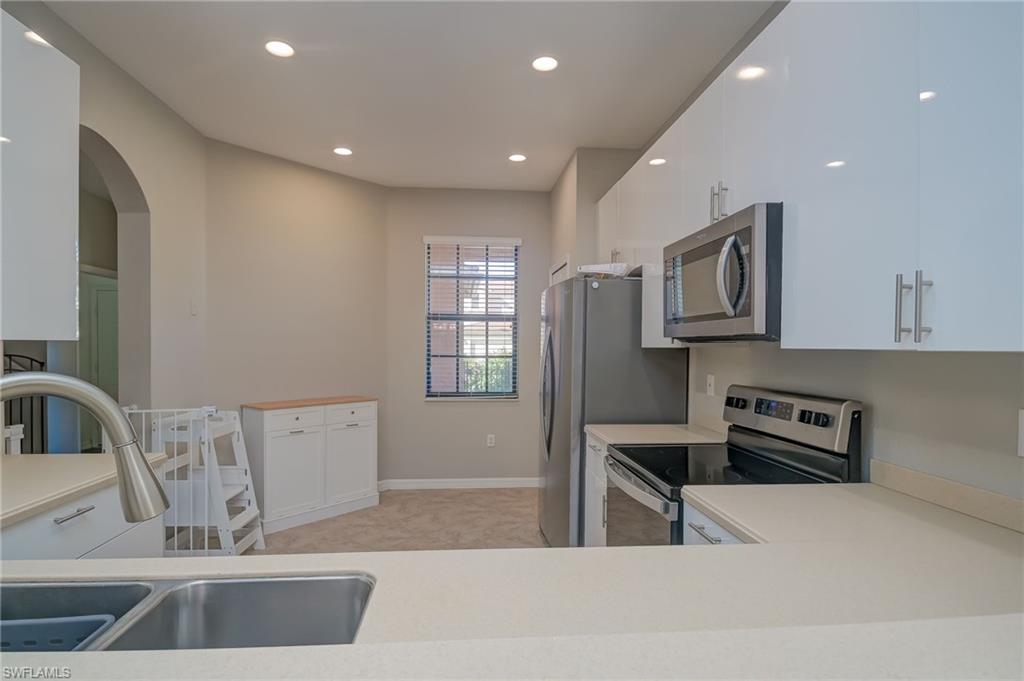 7658 Bristol Circle Naples, FL 34120 - Photo 4 of 32 a kitchen with stainless steel appliances granite countertop a sink and a refrigerator