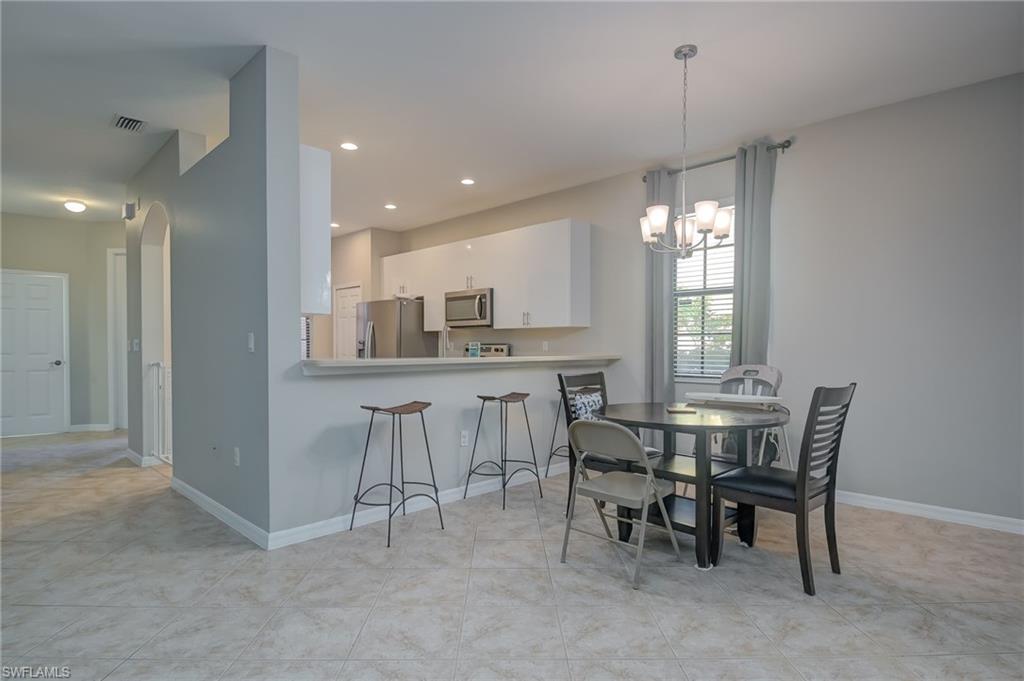 7658 Bristol Circle Naples, FL 34120 - Photo 5 of 32 a view of a dining room with furniture and window