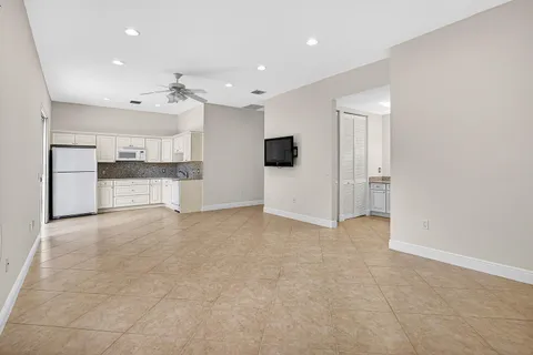 an empty room with windows and ceiling fan