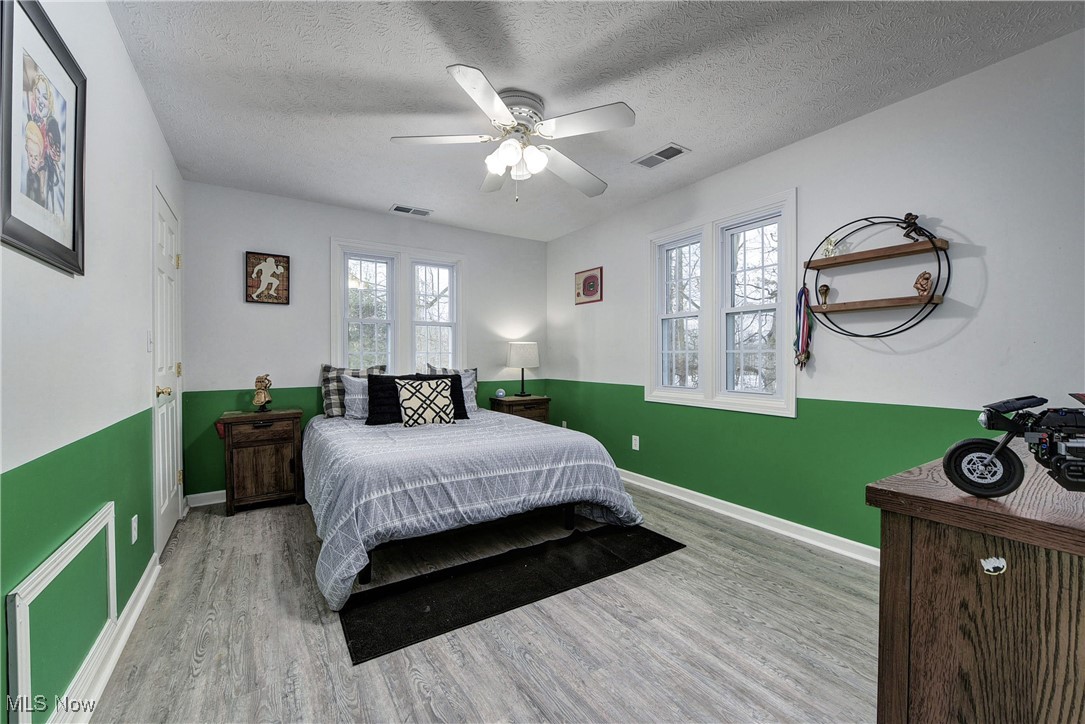 5927 Highland Road Highland Heights, OH 44143 - Photo 20 of 22 Bedroom with multiple windows, ceiling fan, a textured ceiling, and light wood-type flooring