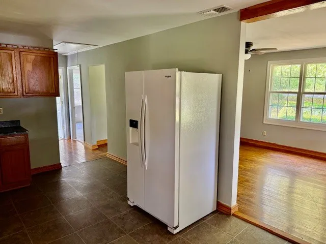 a view of a kitchen with refrigerator and wooden floor