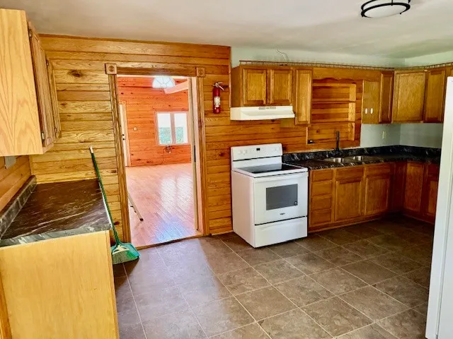 a kitchen with stainless steel appliances granite countertop a stove a sink and a refrigerator