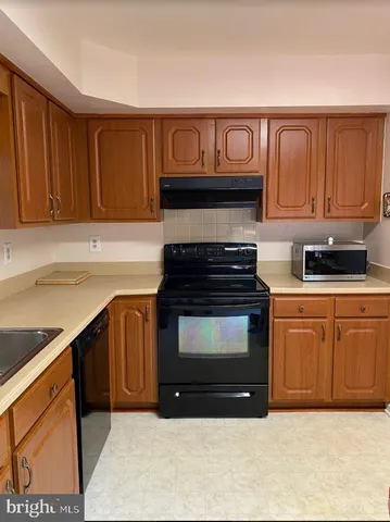 a kitchen with granite countertop a stove top oven cabinetry a sink and dishwasher
