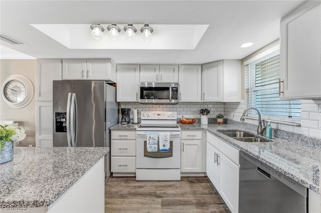 a kitchen with a sink a refrigerator and a stove top oven