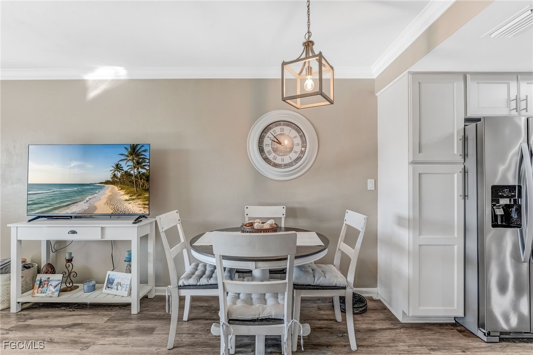16007 Davis Road, Unit 524 Fort Myers, FL 33908 - Photo 11 of 36 a view of a dining room with furniture a kitchen and chandelier