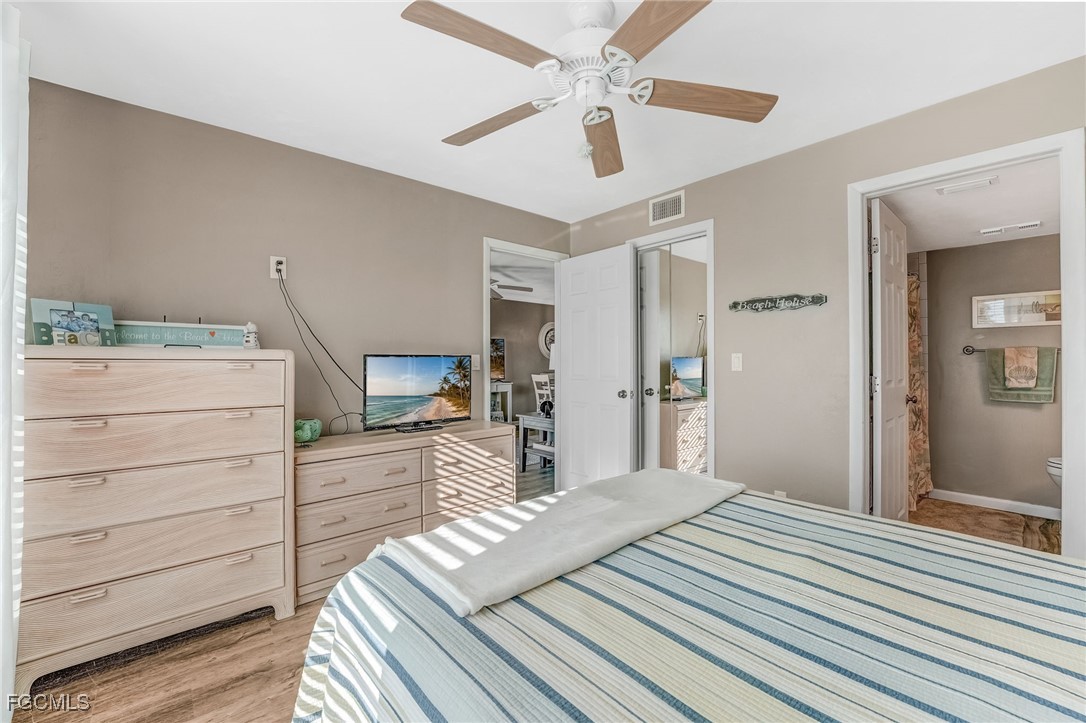 16007 Davis Road, Unit 524 Fort Myers, FL 33908 - Photo 12 of 36 a bedroom with a bed and a chandelier