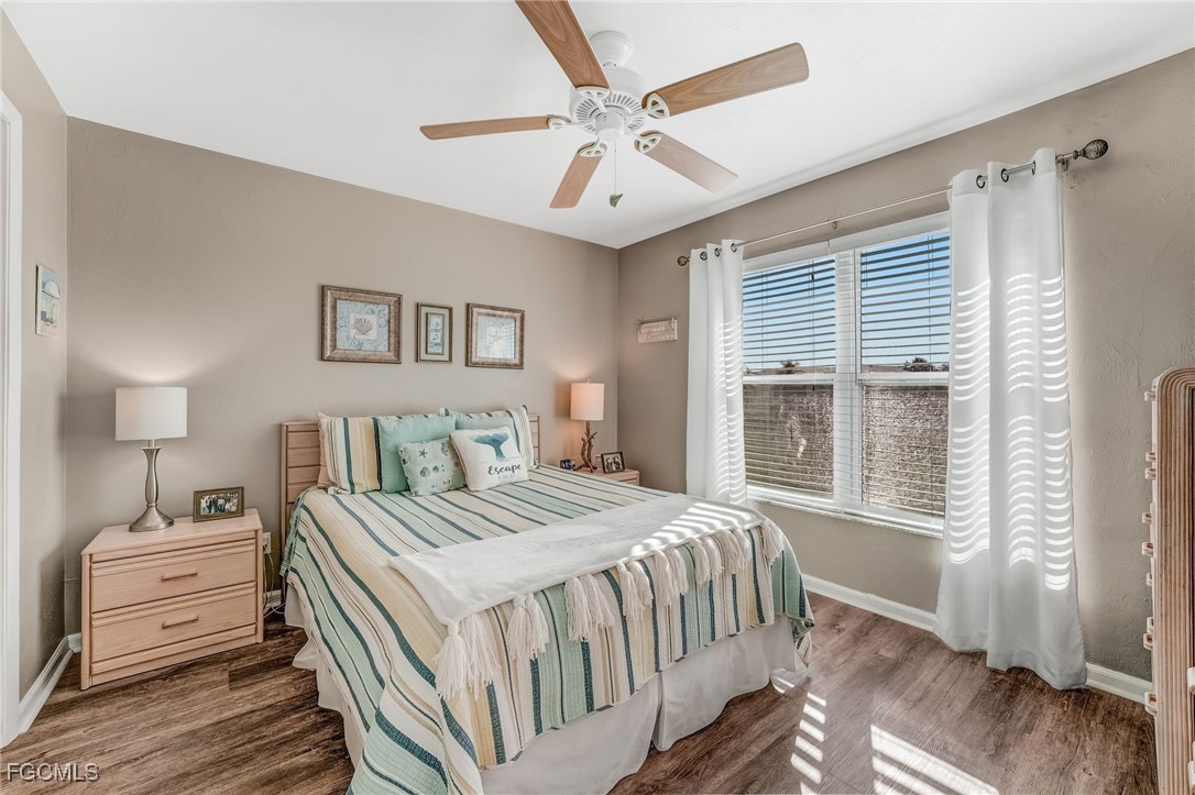 16007 Davis Road, Unit 524 Fort Myers, FL 33908 - Photo 14 of 36 a bedroom with a large bed a chandelier and a window