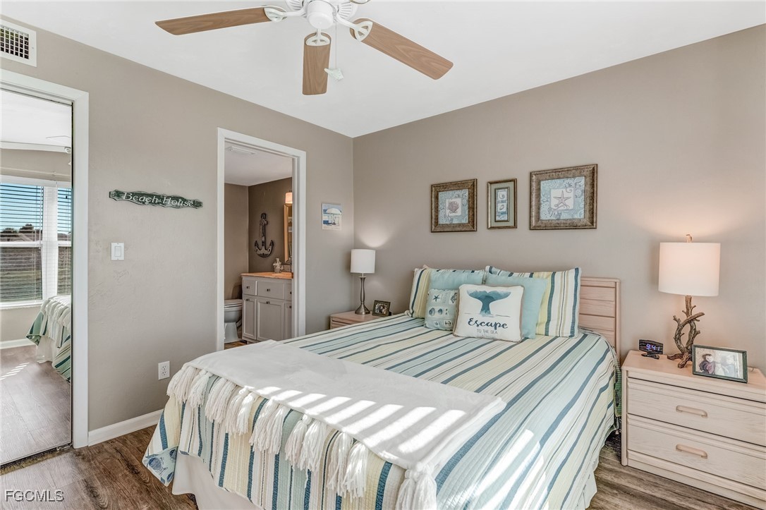 16007 Davis Road, Unit 524 Fort Myers, FL 33908 - Photo 15 of 36 a bedroom with a bed and a chandelier