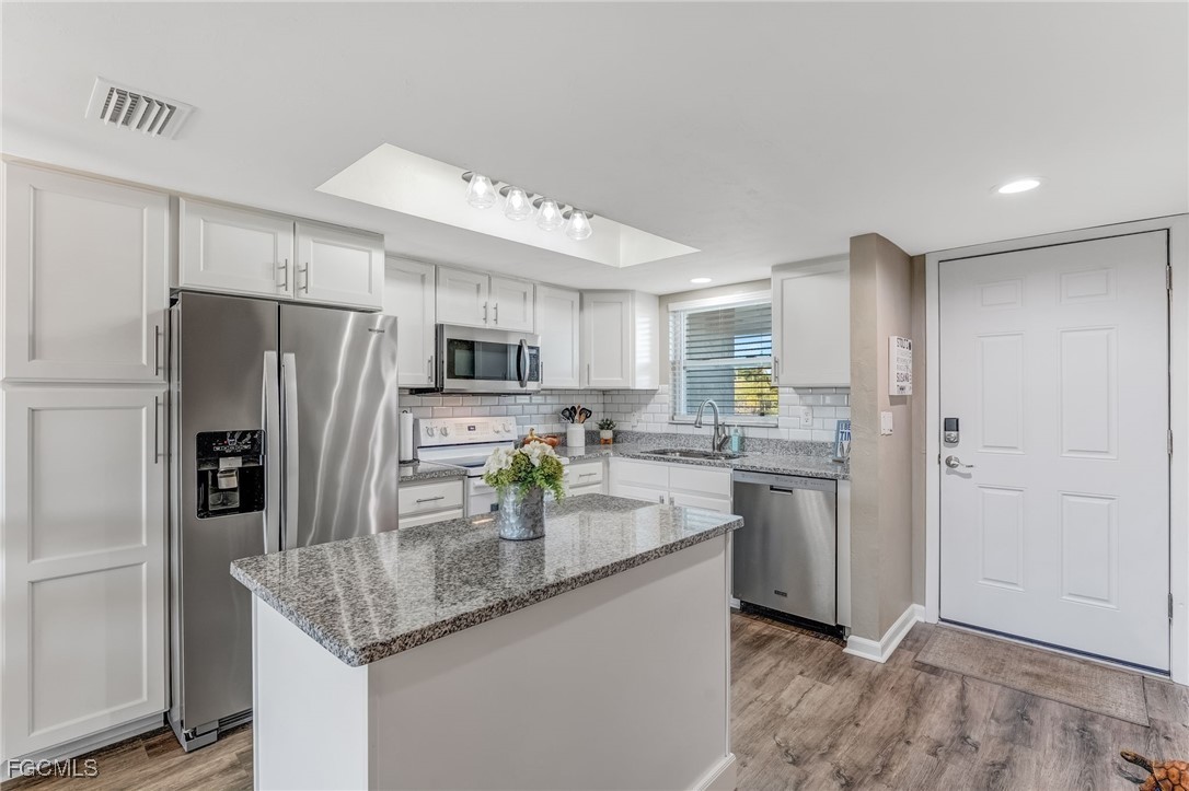 16007 Davis Road, Unit 524 Fort Myers, FL 33908 - Photo 2 of 36 a kitchen with stainless steel appliances granite countertop a refrigerator a stove and a sink