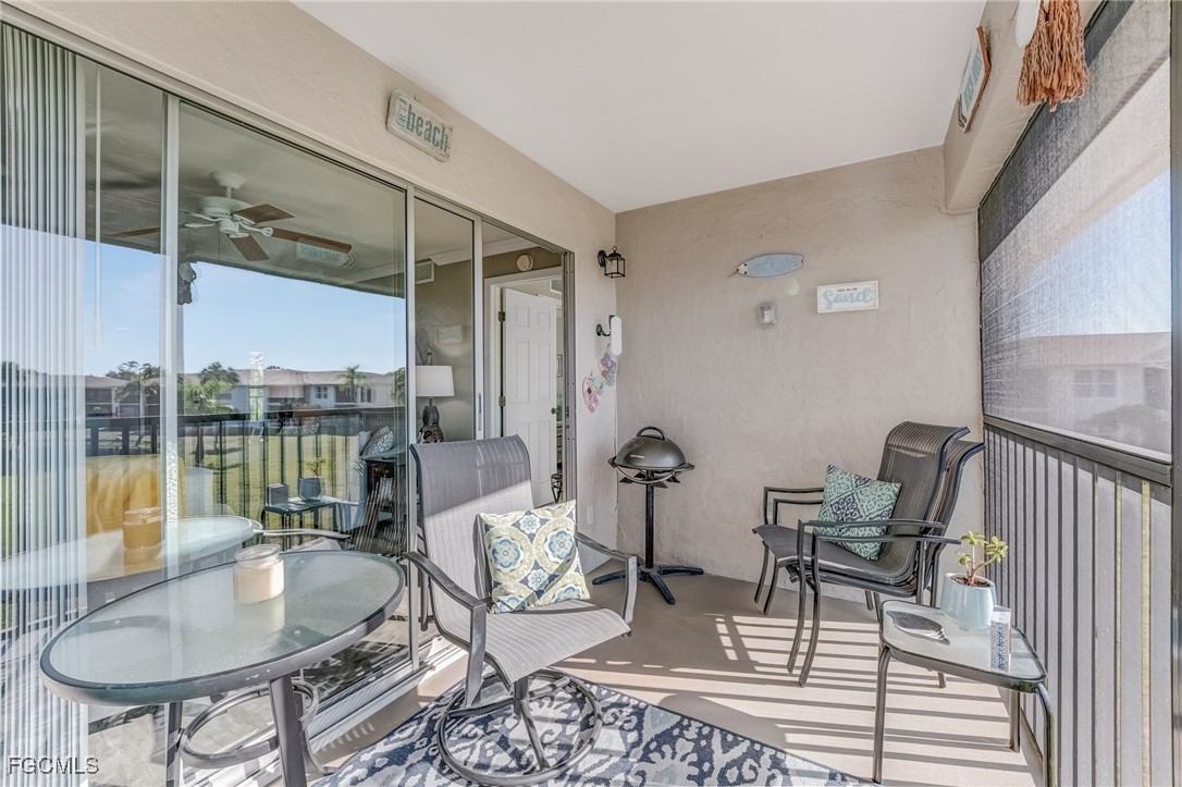 16007 Davis Road, Unit 524 Fort Myers, FL 33908 - Photo 23 of 36 a living room with furniture and a floor to ceiling window