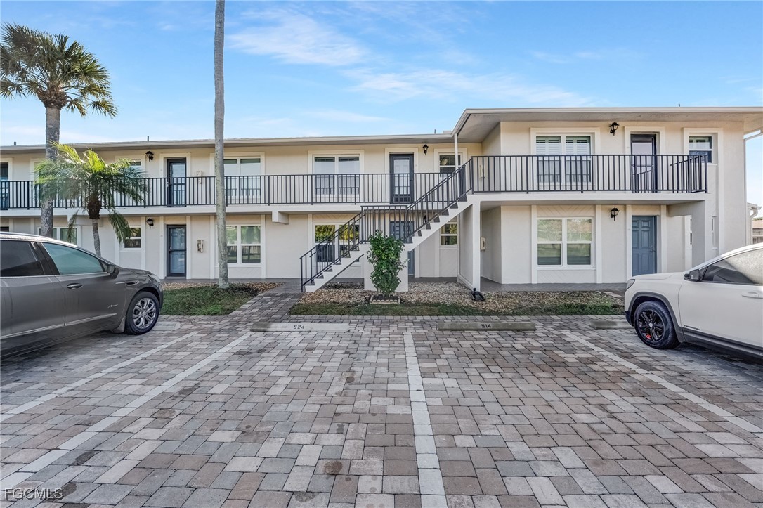 16007 Davis Road, Unit 524 Fort Myers, FL 33908 - Photo 26 of 36 a view of a blue house with a yard and parking space