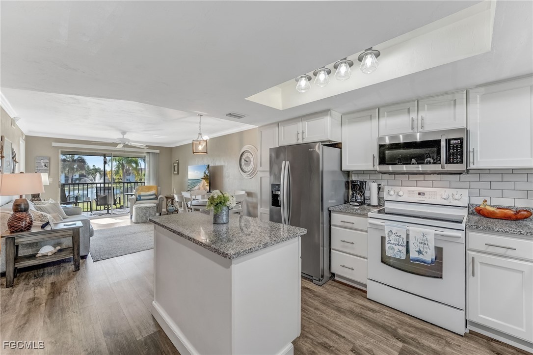 16007 Davis Road, Unit 524 Fort Myers, FL 33908 - Photo 3 of 36 a kitchen with kitchen island granite countertop a sink appliances cabinets and furniture
