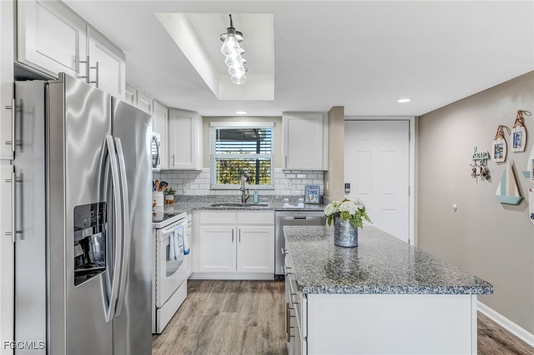 16007 Davis Road, Unit 524 Fort Myers, FL 33908 - Photo 4 of 36 a kitchen with stainless steel appliances granite countertop a refrigerator and a sink