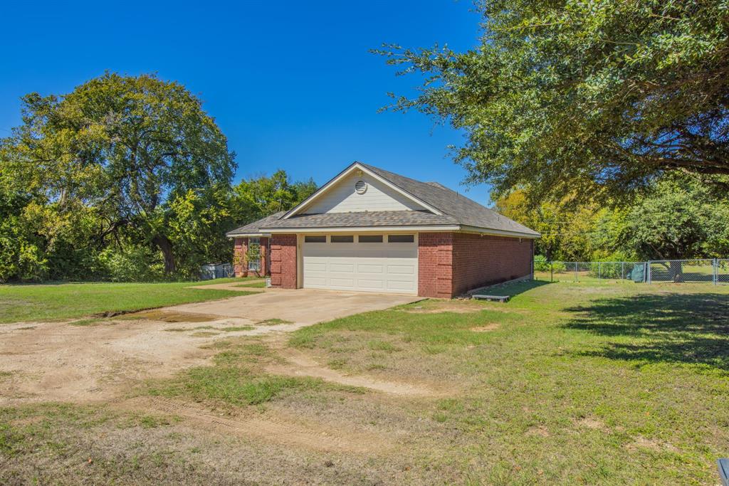 4930 Spring Valley Road Lorena, TX 76655 - Photo 25 of 34 Brick exterior with a peaked gable roofline and an attached garage with a sectional door