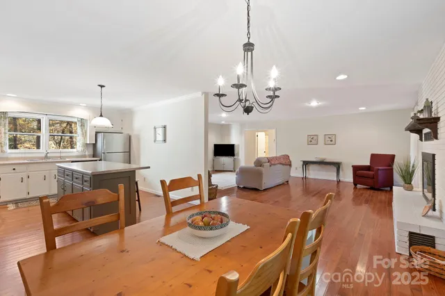 a living room with furniture kitchen view and a chandelier